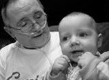 A grandfather on oxygen holding a baby